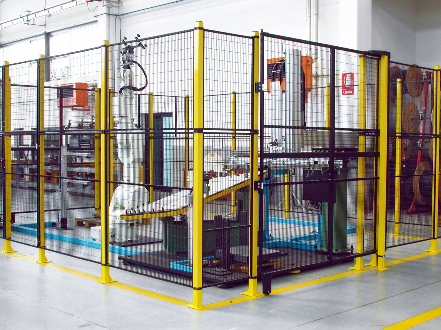 Installation pic of Satech STRONG positioned around antromoprhic robots in the context of an industrial environment