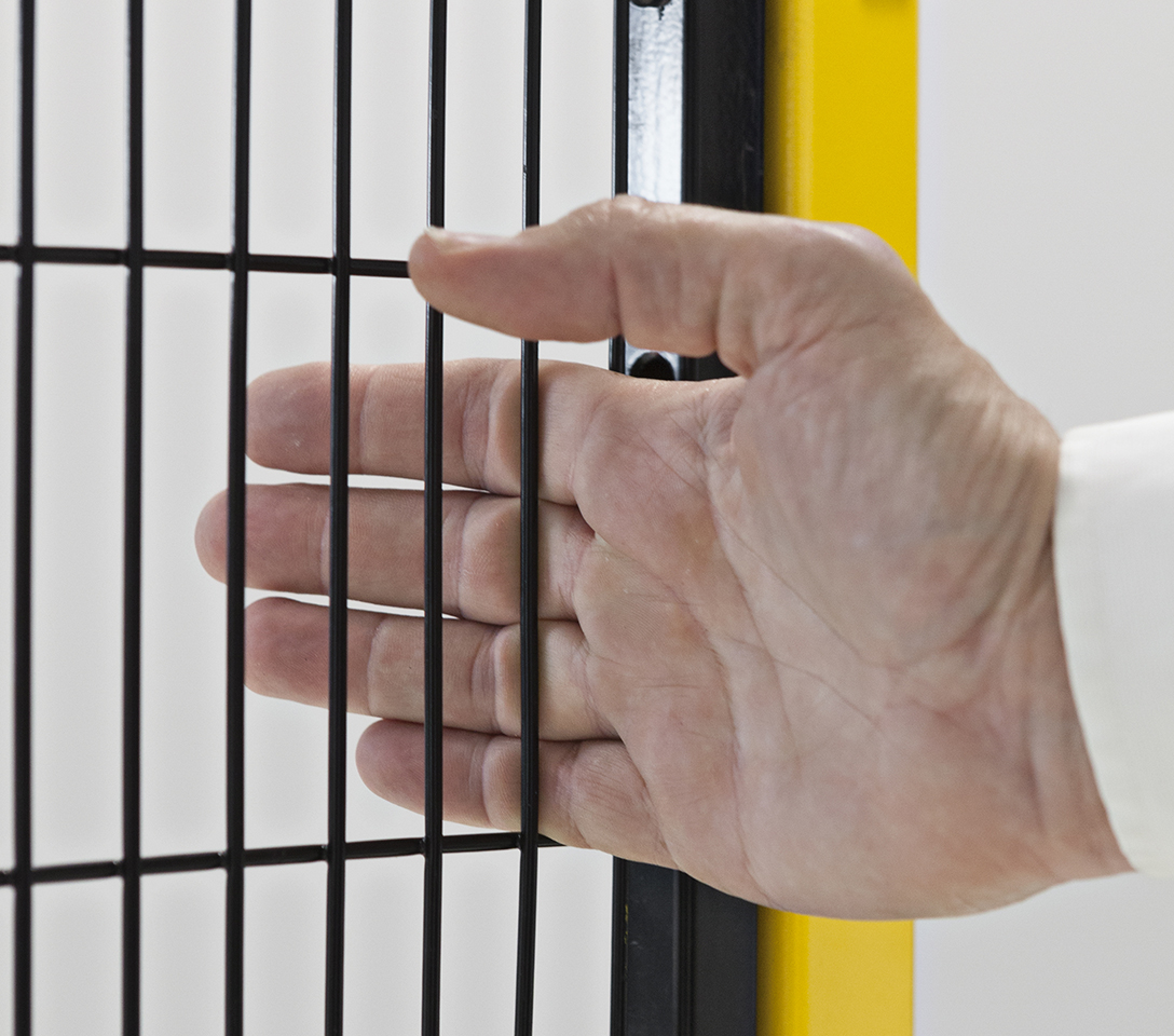 Hand through the mesh slot of Satech framed panels depicting concept of Safety distances as per EN ISO 13857