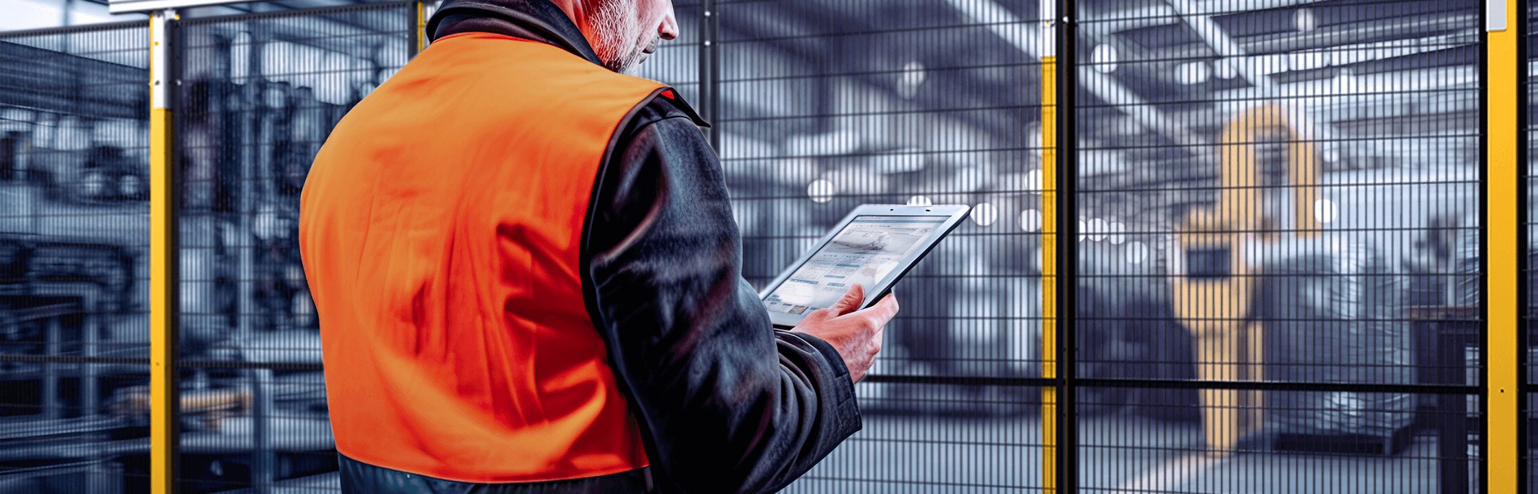 Operator consulting the OSHA website in front of Satech Safety Fencing within an industrial environment