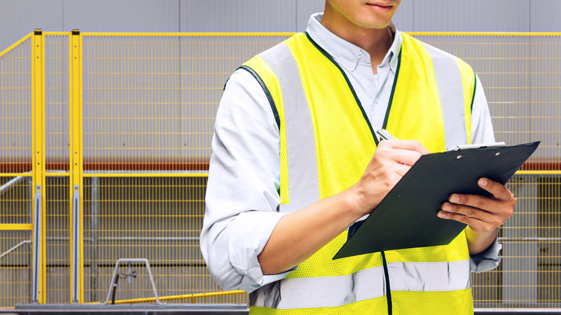 Picture of operator standing in front of OSHA Compliant Fences for the protection of machinery - USAMachineGuards