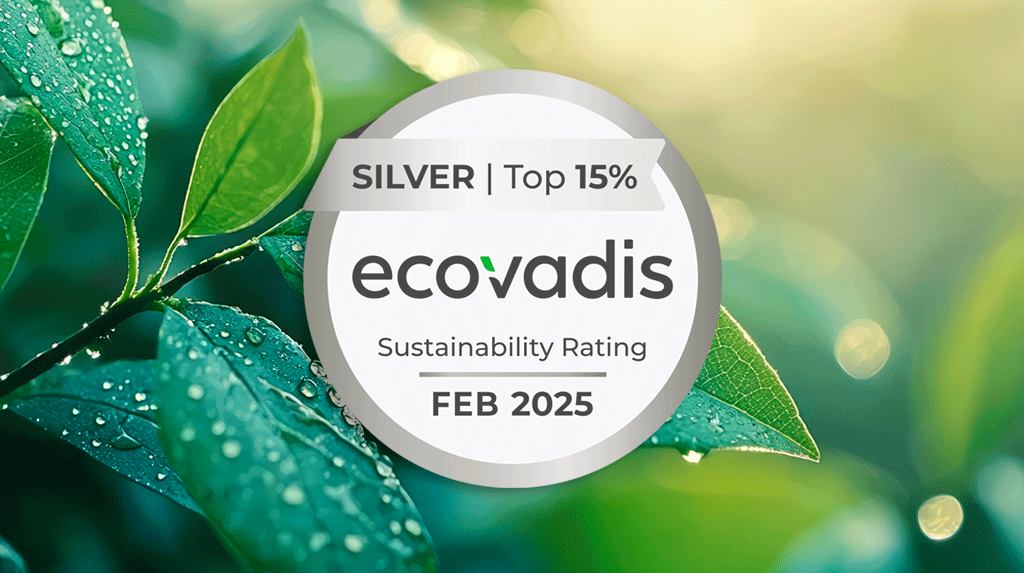 Al centro, il logo della medaglia d'argento della certificazione EcoVadis, rinnovata da Satech nel 2025. Sullo sfondo, dettaglio di una pianta dalle foglie verdi ricoperte da rugiada.