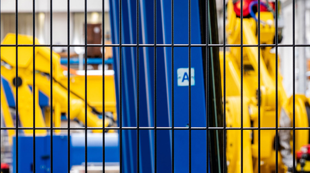 Detail of mesh from Satech perimeter protection fencing blue industrial machinery.